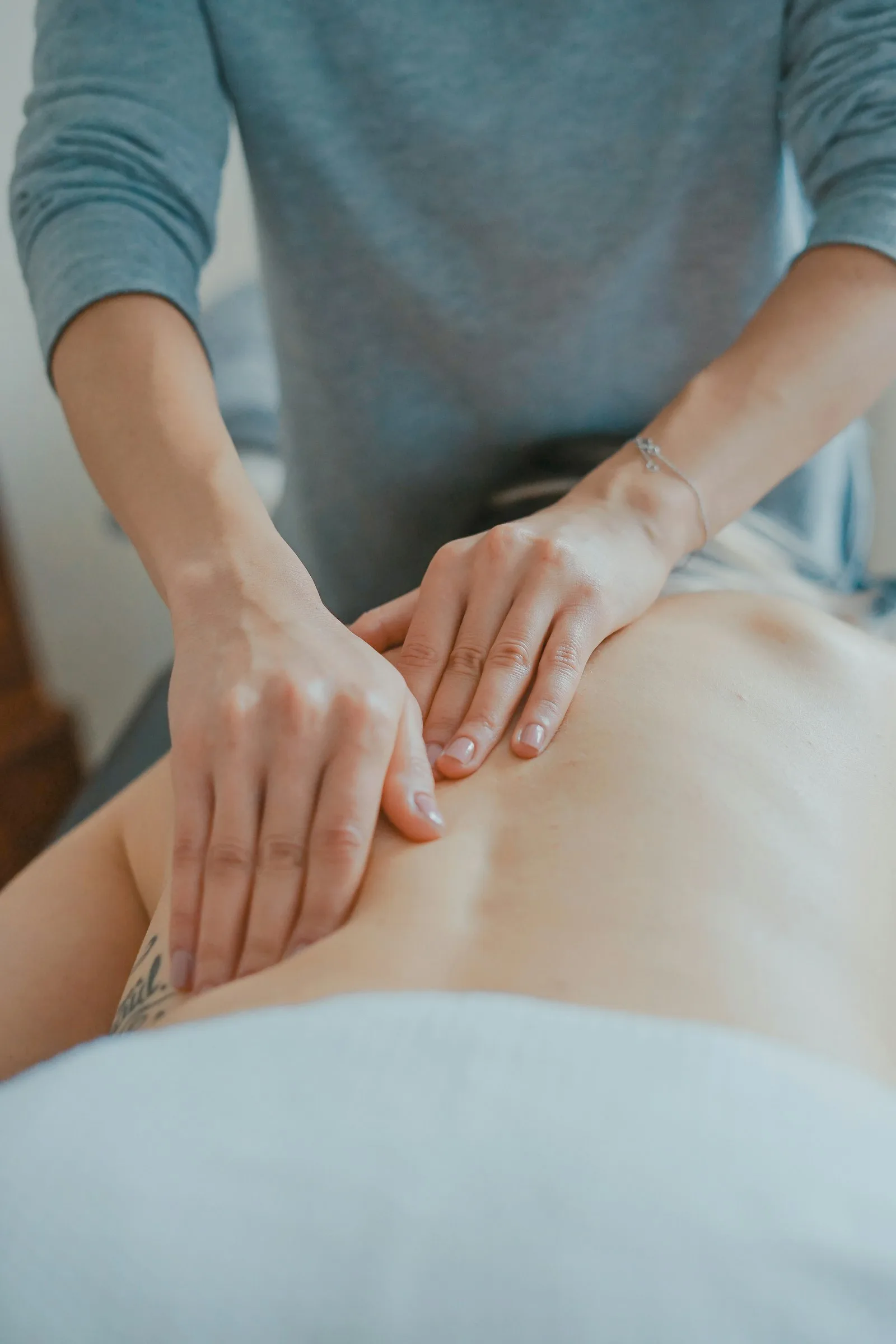 Manos de terapeuta trabajando la espalda en un masaje profundo
