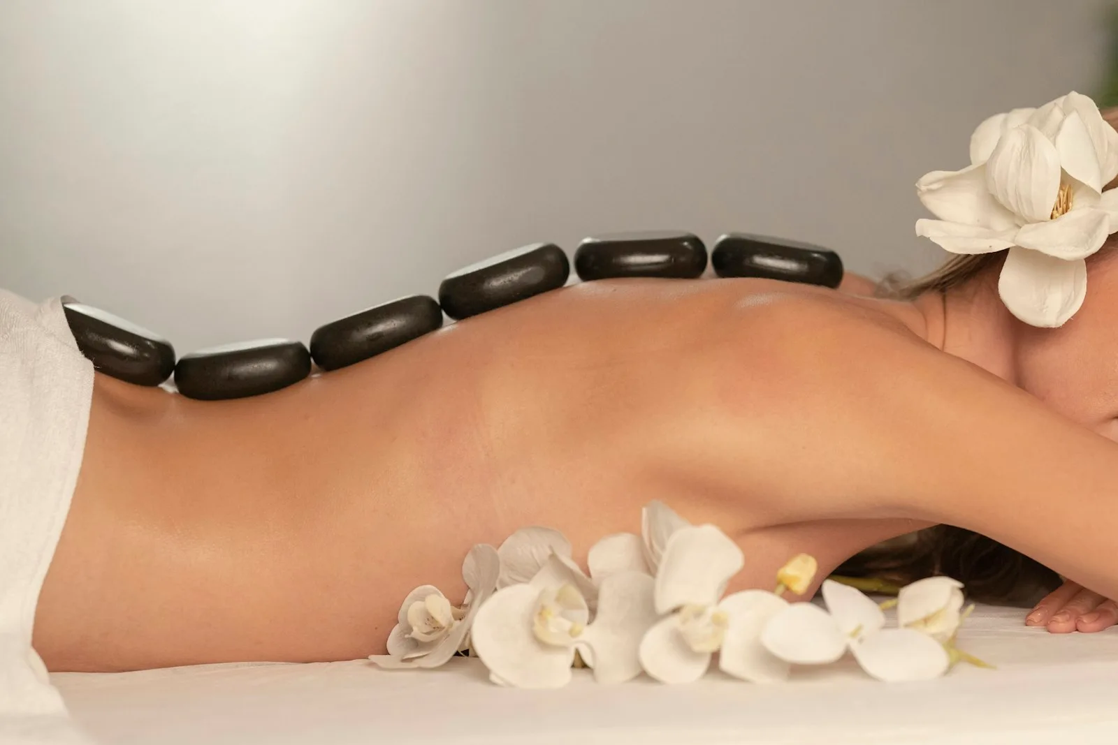 Therapist applying warm basalt stones during a hot stone massage